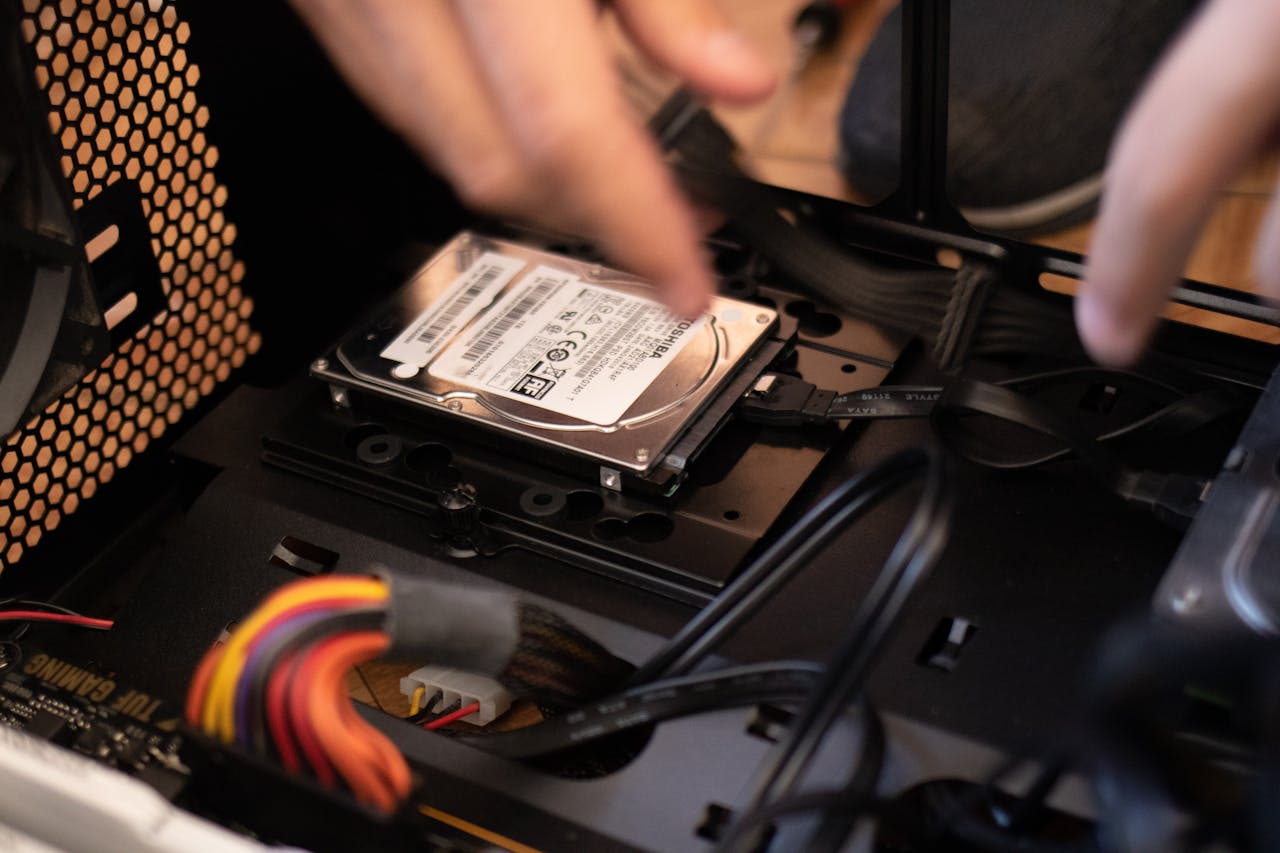home-hero Hands installing a hard drive in a computer case, emphasizing technology and connectivity.
